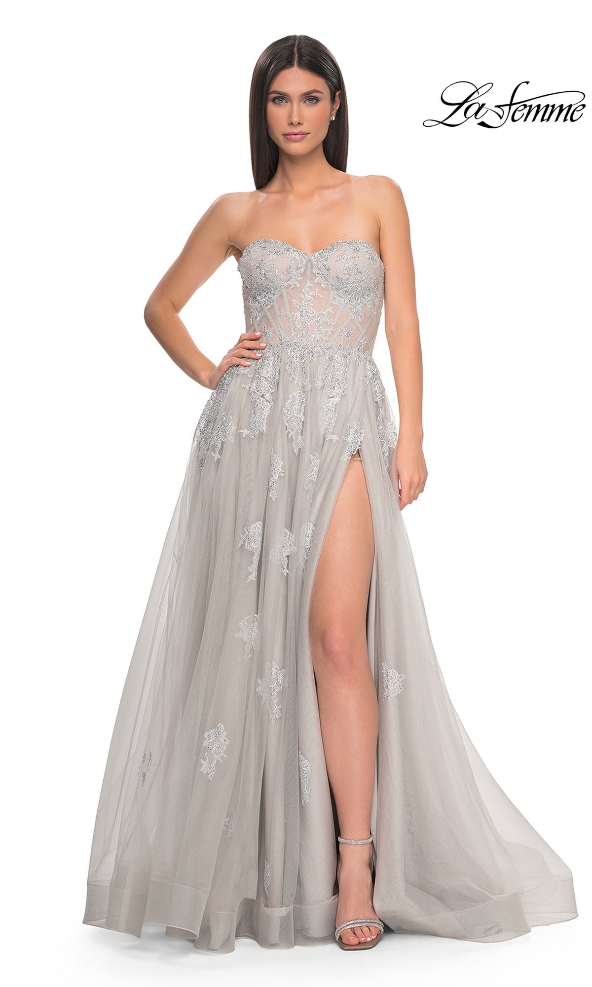 A woman poses against a white background in the La Femme Strapless Long A-Line Prom Dress 32111, featuring embroidered-lace appliques and a high slit. The